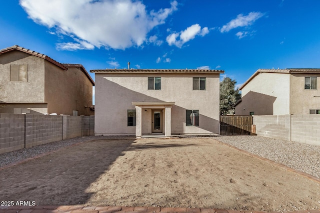 back of house featuring stucco siding and a fenced backyard