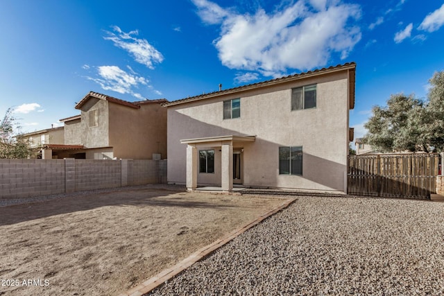 back of house with stucco siding, a fenced backyard, and a patio area