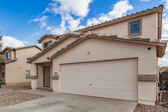 mediterranean / spanish home featuring stucco siding, an attached garage, and concrete driveway