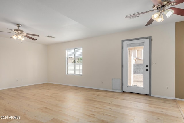 unfurnished room featuring light wood-type flooring, visible vents, and baseboards