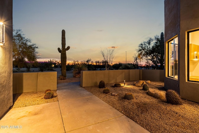 yard at dusk featuring a patio area