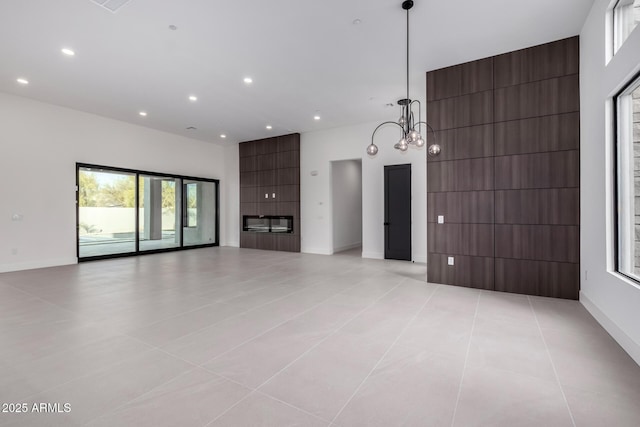 unfurnished living room with a chandelier and light tile patterned floors