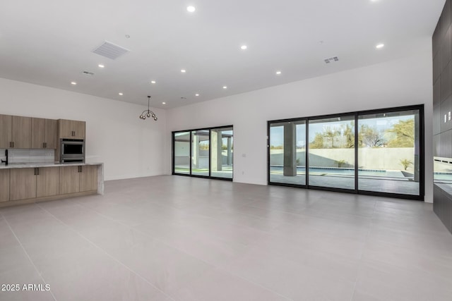 unfurnished living room with a towering ceiling