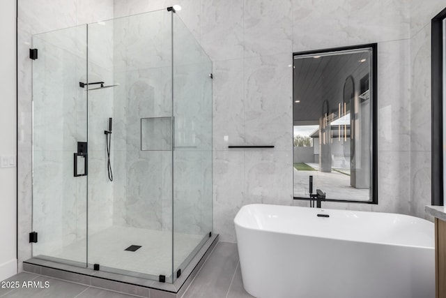 bathroom featuring separate shower and tub and tile walls