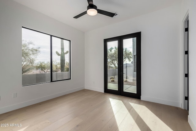 spare room with french doors, ceiling fan, and light wood-type flooring