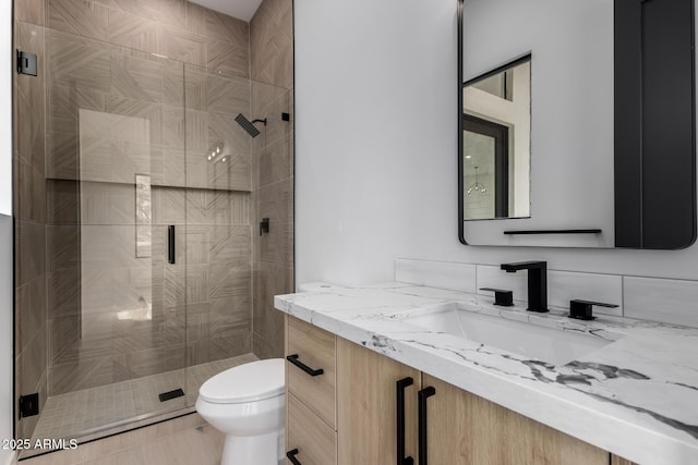 bathroom with vanity, an enclosed shower, and toilet