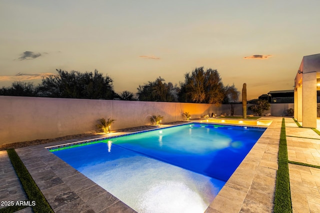 pool at dusk featuring a patio