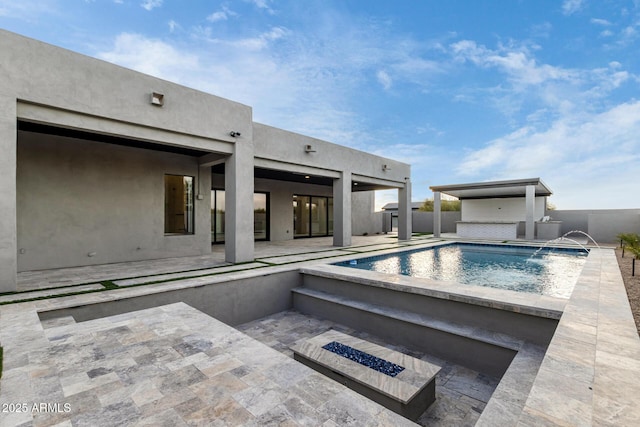 view of swimming pool with a patio, pool water feature, and an outdoor fire pit