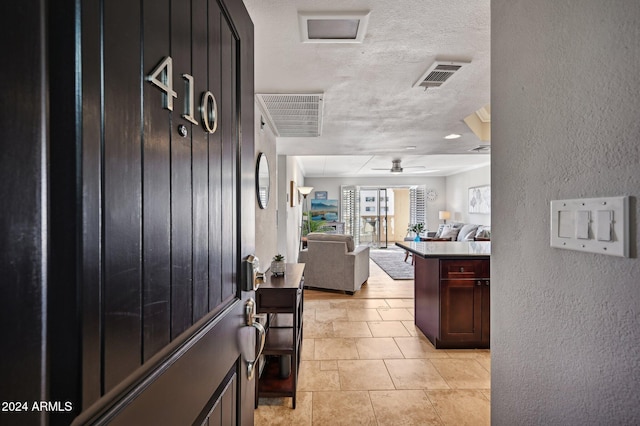 entrance foyer with ceiling fan and a textured ceiling