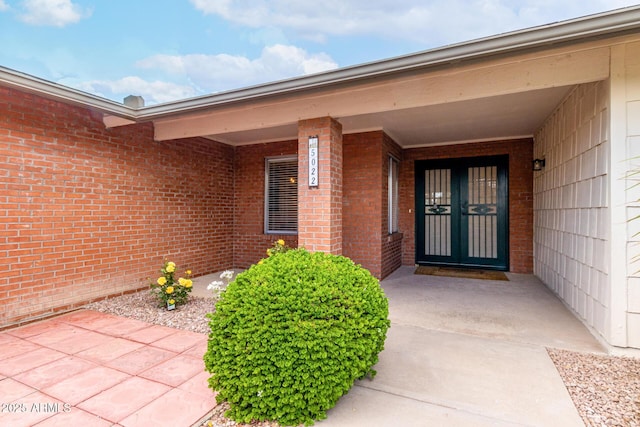 entrance to property featuring brick siding