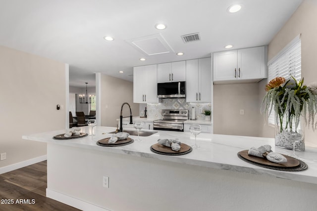 kitchen with visible vents, white cabinets, a sink, appliances with stainless steel finishes, and dark wood finished floors