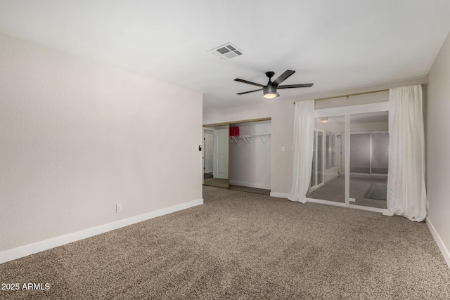 carpeted empty room featuring baseboards, a ceiling fan, and visible vents