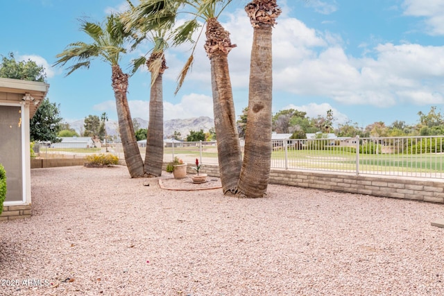 view of yard featuring a mountain view and fence
