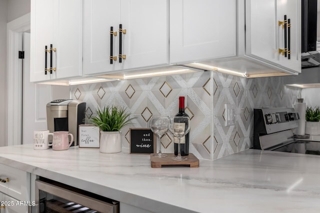 bar with beverage cooler, stainless steel electric stove, and decorative backsplash