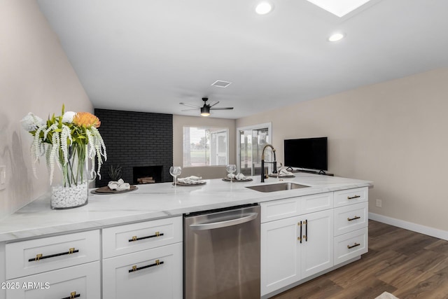 kitchen featuring a fireplace, open floor plan, visible vents, stainless steel dishwasher, and a sink