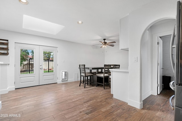 dining room featuring ceiling fan, french doors, recessed lighting, wood finished floors, and a skylight