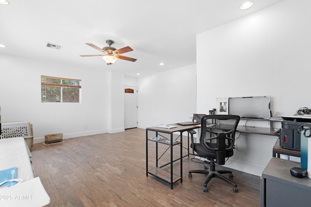 office space featuring a ceiling fan, recessed lighting, wood finished floors, and visible vents