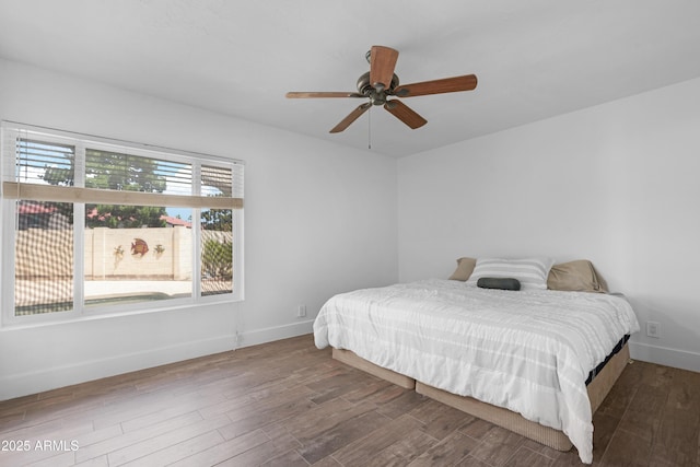 bedroom featuring baseboards, a ceiling fan, and wood finished floors