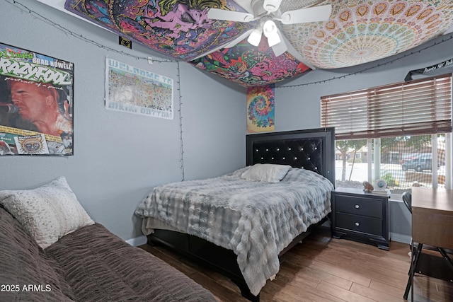 bedroom with baseboards, ceiling fan, and wood finished floors