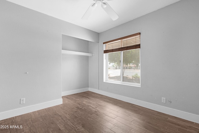 unfurnished room featuring baseboards, ceiling fan, and wood finished floors