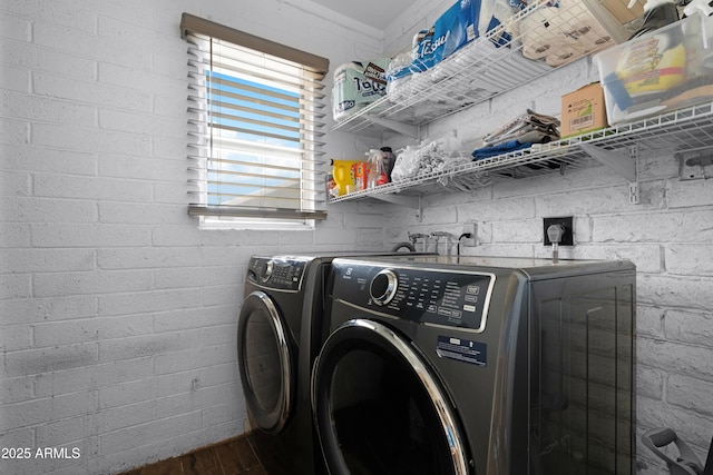 washroom with separate washer and dryer, laundry area, and wood finished floors