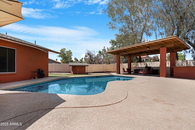 view of pool with a fenced backyard, a storage unit, a fenced in pool, a patio area, and an outbuilding
