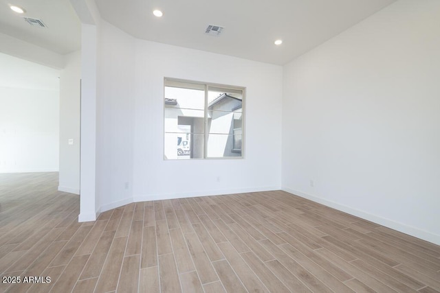 empty room featuring recessed lighting, visible vents, light wood finished floors, and baseboards