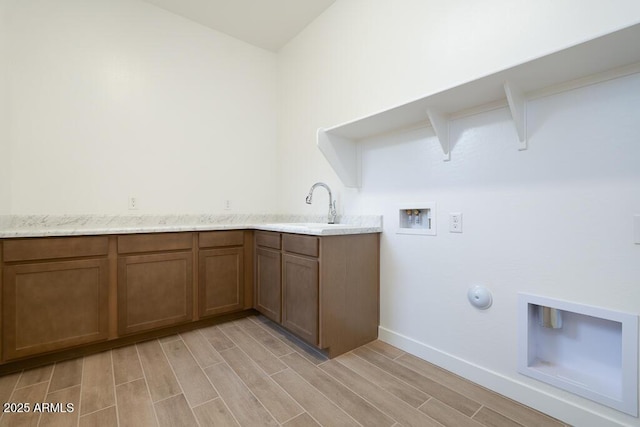 washroom featuring a sink, wood finish floors, gas dryer hookup, and washer hookup