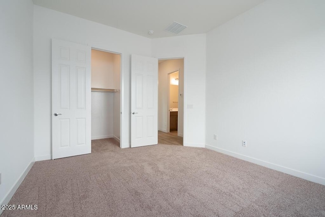 unfurnished bedroom featuring visible vents, baseboards, carpet, and a closet