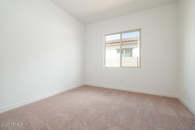 unfurnished room with light carpet, baseboards, and vaulted ceiling