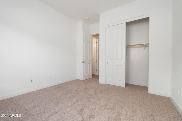 unfurnished bedroom featuring a closet, baseboards, and carpet