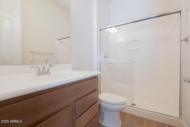 full bath with vanity, toilet, wood finished floors, and a stall shower