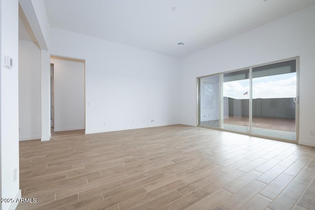 unfurnished room with baseboards and light wood finished floors