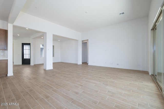 empty room featuring light wood-style flooring, recessed lighting, baseboards, and visible vents