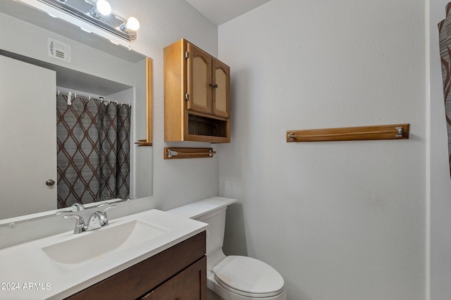 bathroom with visible vents, vanity, and toilet