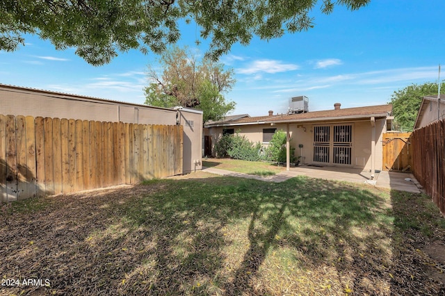 view of yard featuring a fenced backyard, a patio, and central air condition unit