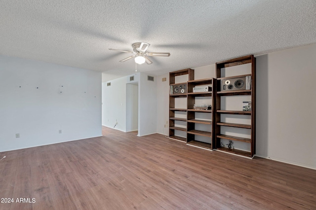 spare room with ceiling fan, wood-type flooring, and a textured ceiling