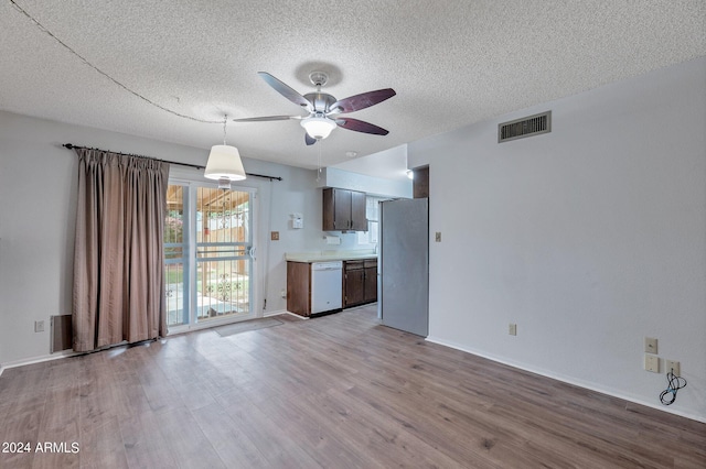 unfurnished living room with visible vents, ceiling fan, a textured ceiling, and wood finished floors