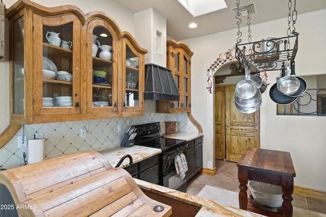 21909 W Beacon Ln, Wittmann, AZ 85361 - kitchen with visible vents, electric range, baseboards, backsplash, and a skylight