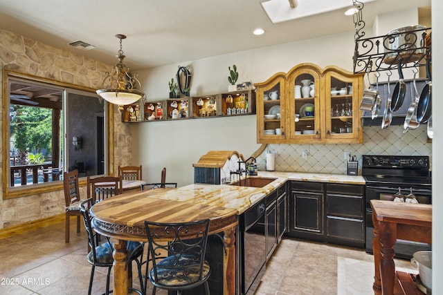 21909 W Beacon Ln, Wittmann, AZ 85361 - kitchen featuring a sink, tasteful backsplash, a skylight, glass insert cabinets, and black appliances