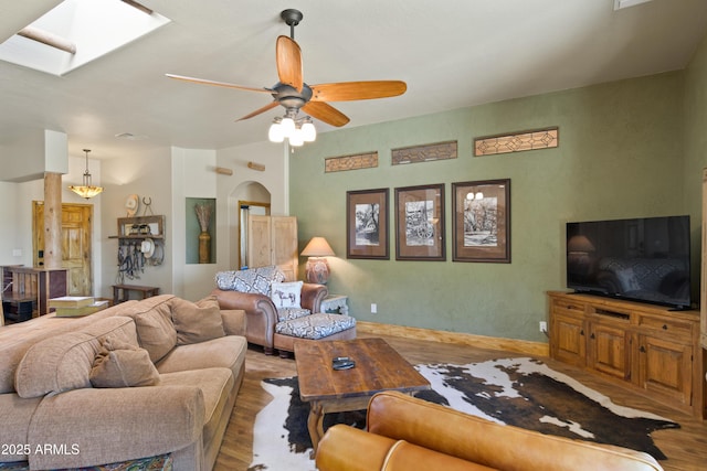 21909 W Beacon Ln, Wittmann, AZ 85361 - living area with a skylight, arched walkways, a ceiling fan, and wood finished floors