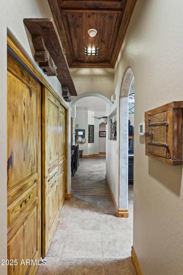 21909 W Beacon Ln, Wittmann, AZ 85361 - corridor featuring wooden ceiling, arched walkways, baseboards, and ornamental molding