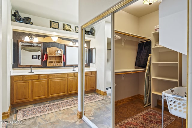 21909 W Beacon Ln, Wittmann, AZ 85361 - full bath featuring baseboards, double vanity, a sink, and a spacious closet