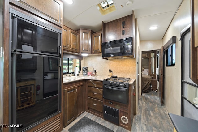 21909 W Beacon Ln, Wittmann, AZ 85361 - kitchen with backsplash, black microwave, fridge, light countertops, and dark wood-type flooring