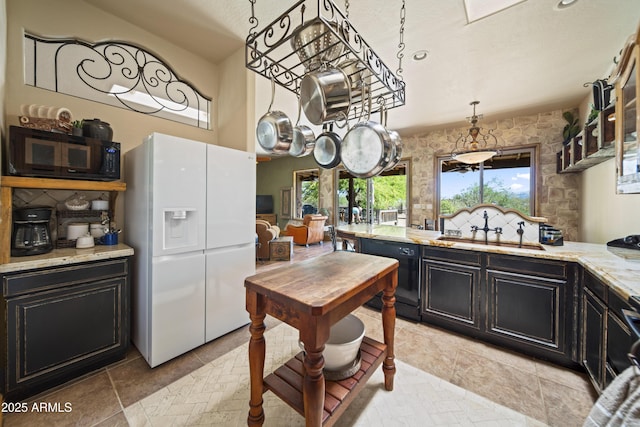 21909 W Beacon Ln, Wittmann, AZ 85361 - kitchen featuring dark cabinetry, light stone counters, a sink, and black appliances