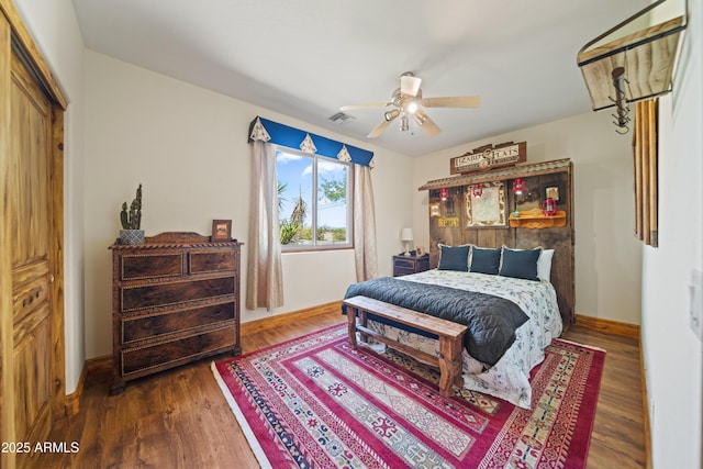 21909 W Beacon Ln, Wittmann, AZ 85361 - bedroom featuring visible vents, a ceiling fan, baseboards, and wood finished floors