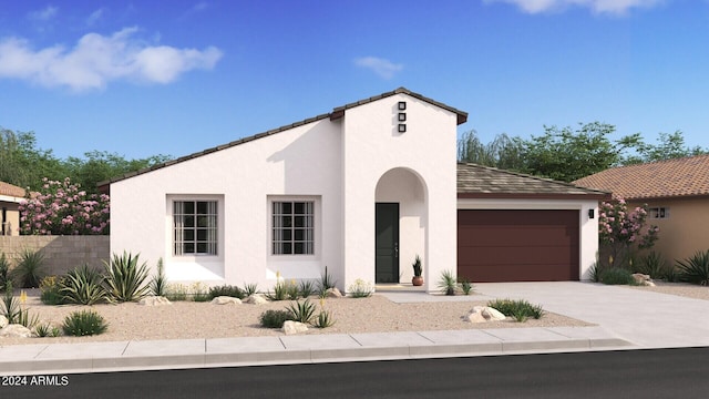 mediterranean / spanish home featuring concrete driveway, an attached garage, fence, and stucco siding