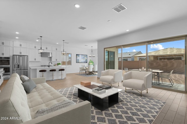 living room featuring a chandelier, recessed lighting, visible vents, and wood finished floors