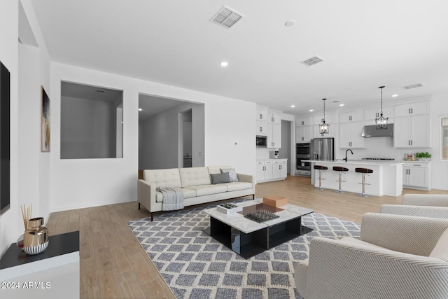 living area with light wood-type flooring, visible vents, and recessed lighting