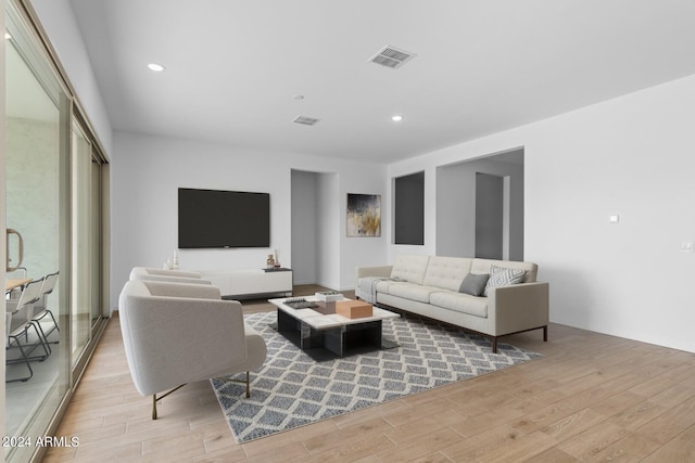 living room featuring light wood-style flooring, visible vents, and recessed lighting